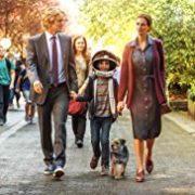 Still from Wonder: a boy in an astronaut helmet walks hand in hand with his parents and their dog