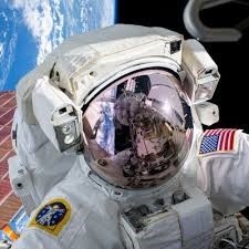 Close-up of an astronaut in a NASA EVA spacesuit on a spacewalk, Earth reflected in the visor
