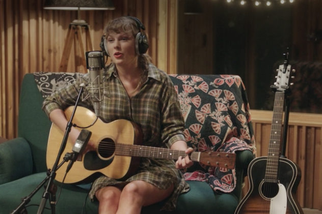 Taylor Swift plays acoustic guitar in headphones at a mic in Long Pond Studio for the Folklore sessions