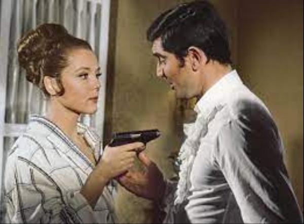 Diana Rigg holds a pistol on George Lazenby in On Her Majesty's Secret Service