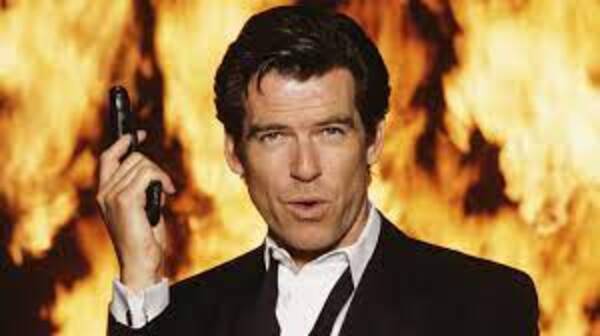 Pierce Brosnan as James Bond in GoldenEye, holding a pistol against a wall of flame