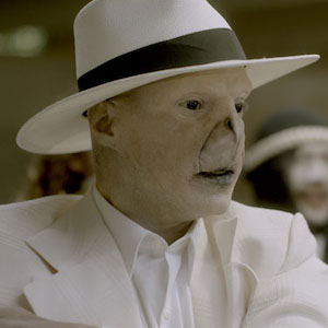 Still from I'm An Electric Lampshade: a man in white face paint, white suit and white hat