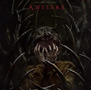 Poster for Antlers: a boy covers his face with his hands amid dark, claw-like antlers