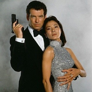 Tomorrow Never Dies promo: Pierce Brosnan as Bond holds a pistol beside his co-star in a silver dress