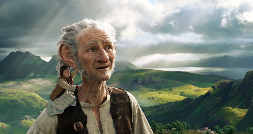 Still from The BFG: the giant stands in green highlands with Sophie on his shoulder