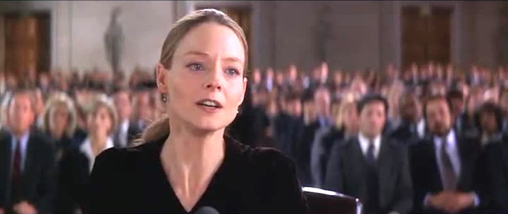 Still from Contact: Ellie Arroway testifies before a packed hearing room