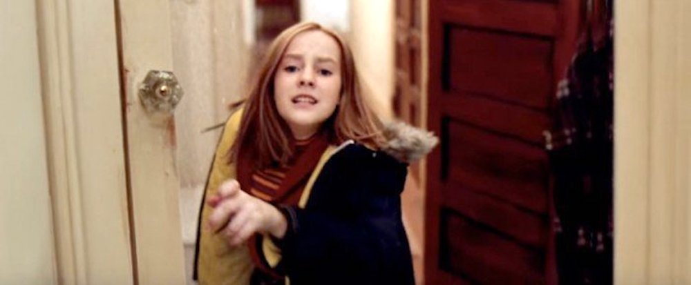Still from Contact: young Ellie, in a scarf and coat, runs through a doorway
