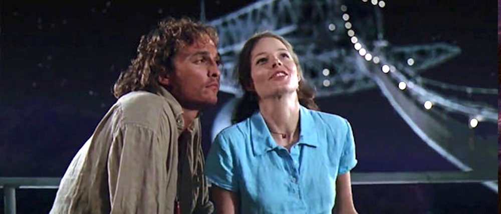 Still from Contact: a man and a woman gaze upward on a gantry at night