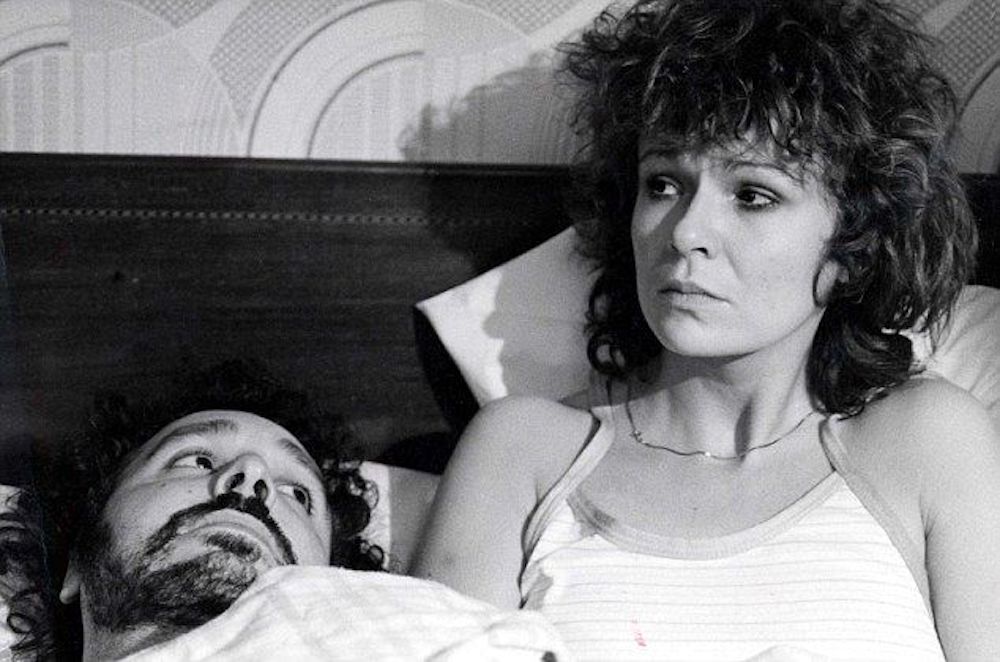 Still from Boys from the Blackstuff (1982): Julie Walters sits up in bed beside Michael Angelis