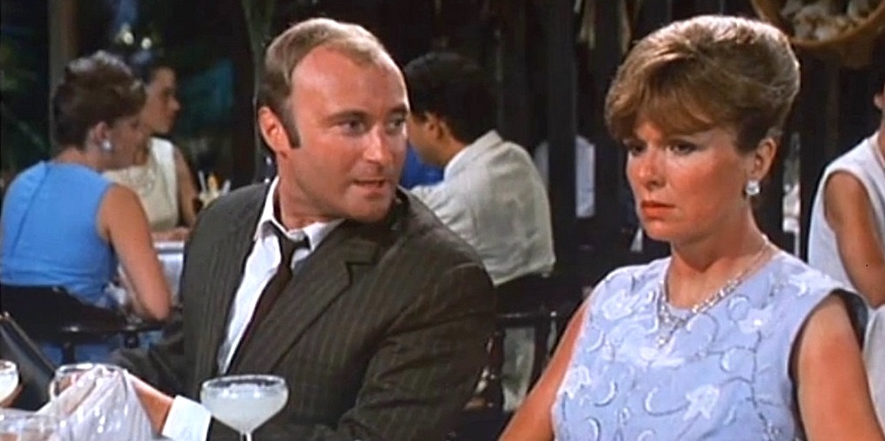 Phil Collins and Julie Walters at a restaurant table in Buster (1988)