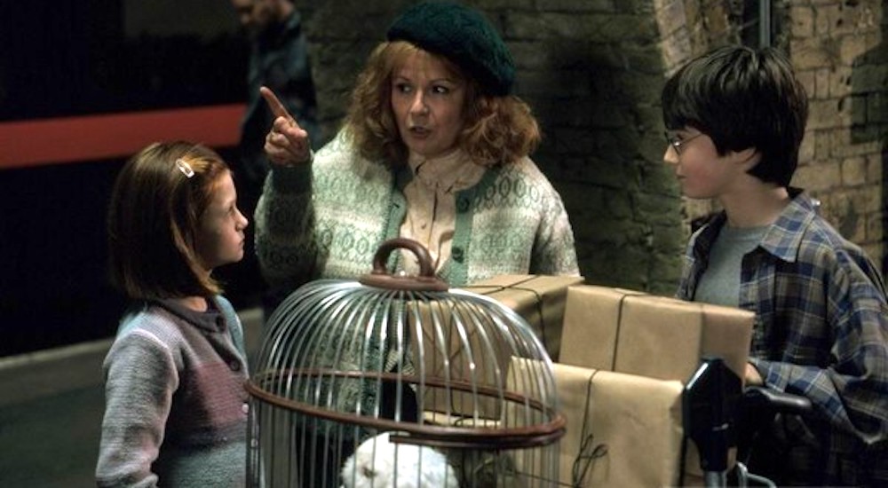 Still from Harry Potter and the Philosopher's Stone: Julie Walters as Mrs Weasley points the way for Harry and Ginny