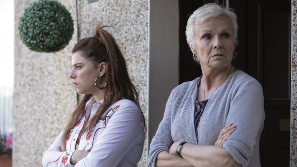 Still from Wild Rose (2018): Jessie Buckley and Julie Walters stand arms folded outside a house