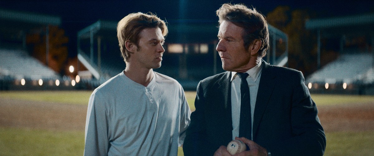 Still from The Hill: a young ballplayer and a man in a suit holding a baseball on a night field