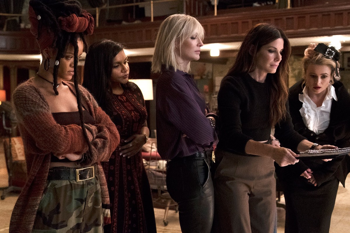 Still from Ocean's 8: five members of the crew gather around a necklace display