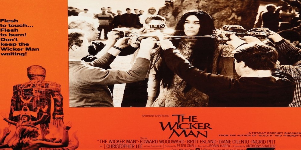 Lobby card for The Wicker Man (1973): villagers bind a woman, with the burning wicker figure in the corner