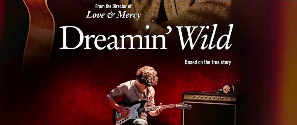 Banner for Dreamin' Wild: a young man plays electric guitar beside an amp on a red stage