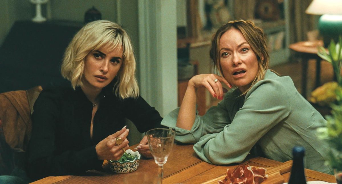 Still from The Invite: two women sit at a dinner table, one looking startled