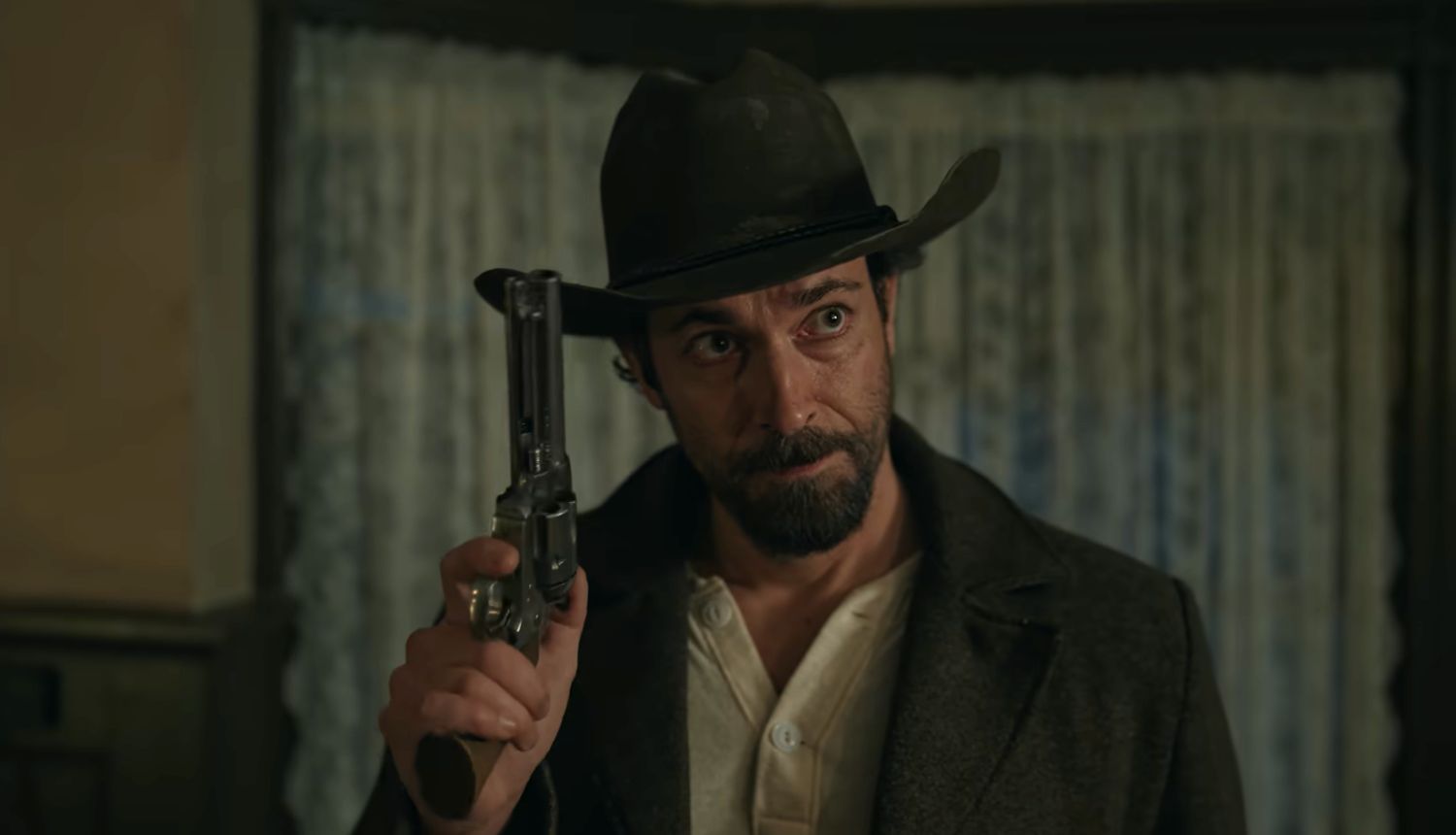 Still from Angel and the Badman: a bearded gunman in a black hat holds up a revolver